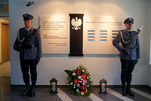 dwaj policjanci stoją przy ścianie pamięci poległych policjantów