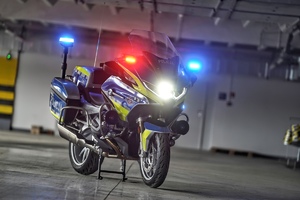 Policyjny motocykl z włączonymi światłami.