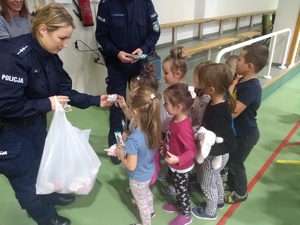 Policjantka rozdająca nagrody dzieciom.