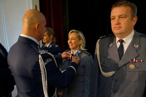 Komendant przypina medal policjantce
