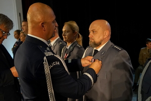 Komendant przypina medal policjantowi