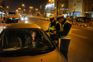 funkcjonariusze kontrolują kierowcę taksówki