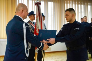 Komendant podaje dłoń policjantowi