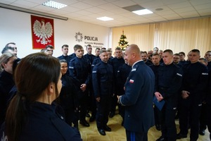 Komendant przemawia do nowo przyjętych policjantów którzy stoją obok niego