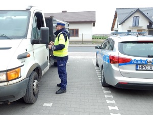 policjant kontroluje zatrzymany samochód