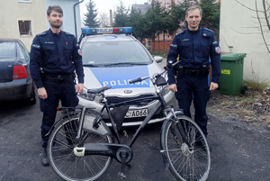 Policjanci stoją przy odzyskanym rowerze