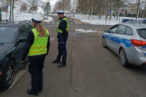 Policjanci kontrolują zatrzymany samochód