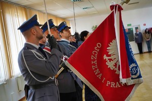 ujęcie na policjantów, którzy trzymają szablę i sztandarowy komendy wojewódzkiej