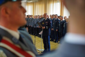 ujęcie zza ramienia policjanta na Komendanta Wojewódzkiego Policji w Bydgoszczy, który czyta Rotę ślubowania