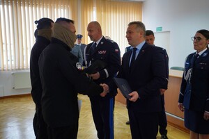Wojewoda i Komendant Wojewódzki Policji w Bydgoszczy, podając rękę, gratuluje policjantom Samodzielnego Pododdziału Kontrterrorystycznego Policji, którzy mają założone maskujące chusty na twarzy