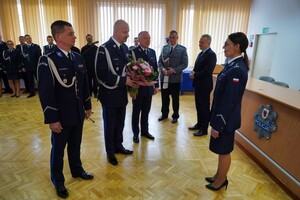 Komendant Wojewódzki Policji w Bydgoszczy oraz jego Zastępcy stoją przed inspektor Małgorzatą Jorką i składają życzenia. Komendant trzyma bukiet kwiatów
