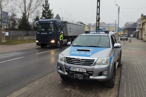 Policjant stoi przy samochodzie zatrzymanym do kontroli i sprawdza trzeźwość kierowcy