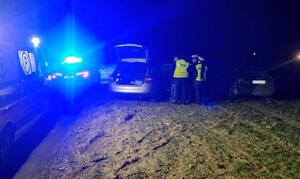 Policjanci stoją pomiędzy radiowozem, a audi uciekiniera