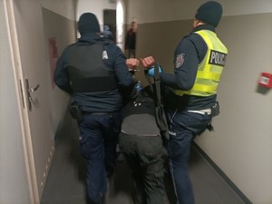 Policjanci prowadzą zatrzymanego mężczyznę