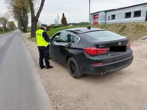 policjant kontroluje samochód zatrzymany do kontroli