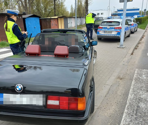 policjantka kontroluje samochód zatrzymany do kontroli