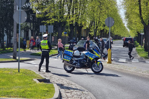 Policjant stoi przy przejściu dla pieszych i czuwa nad bezpieczeństwem pieszych