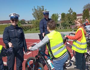 Policjanci podają dłonie rowerzystom ubranym w żółte kamizelki