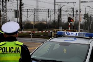 Policjant przy przejeździe kolejowym.