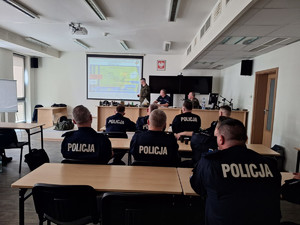 Policjanci i żołnierze na sali wykładowej.
