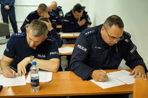Policjanci za stołem w czasie egzaminu.