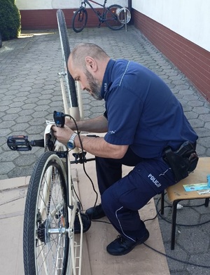 Policjant podczas znakowania roweru.