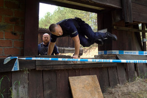 policjant przeskakuje przez przeszkodę