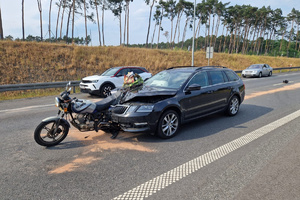 Widok na rozbity motocykl i samochód osobowy