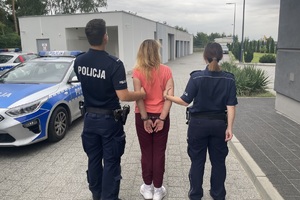 Zatrzymana w asyście policjantów.