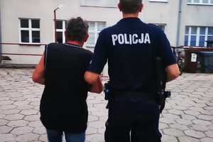 Policjant prowadzi zatrzymanego pijanego kierowcę