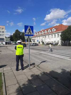 policjant stoi przy przejściu dla pieszych