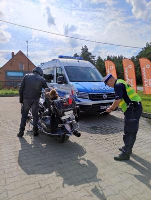 policjant nachyla się przy motocyklu