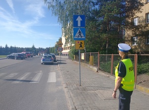 Policjantka stoi w pobliżu szkoły