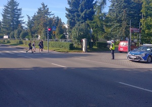Policjant czuwa nad bezpieczeństwem uczniów przechodzących po pasach