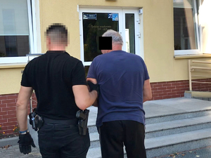 Policjanci prowadzą zatrzymanego mężczyznę