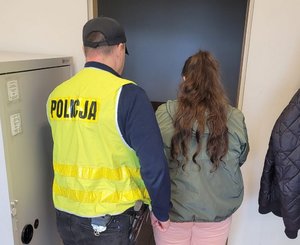 Policjant prowadzi zatrzymana złodziejkę