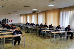 policjanci siedzą w ławkach i rozwiązują test