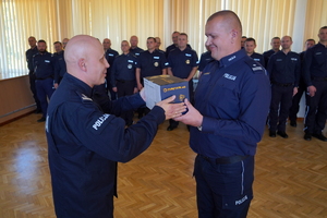 Przewodniczący policyjnych związków zawodowych wręcza policjantowi nagrodę