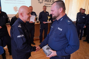Przewodniczący policyjnych związków zawodowych wręcza policjantowi nagrodę