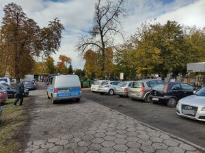 Radiowóz na parkingu przy cmentarzu.