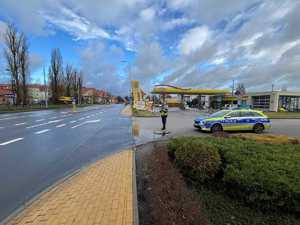 Policjant na stacji paliw, mierzy prędkość na drodze.