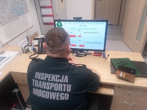 Funkcjonariusz ITD siedzi przed monitorem