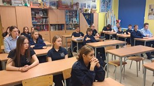 policjant rozmawia z uczniami w klasie
