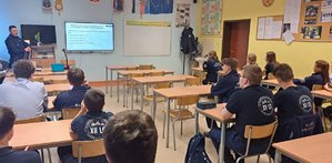 policjant rozmawia z uczniami w klasie