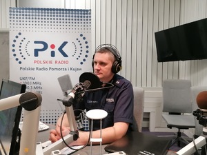 policjant uczestniczy w audycji radiowej