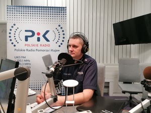 policjant uczestniczy w audycji radiowej