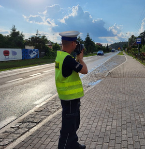 Policjant na drodze podczas pomiaru prędkości.