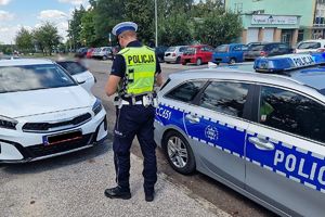 Policjant RD kontroluje kierowcę białej kii