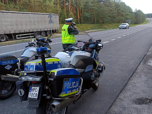 Policjanci ruchu drogowego na motocyklach w czasie pracy na drodze.