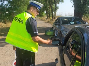 Policjant ruchu drogowego pokazuje prędkość, z jaka jechał kontrolowany kierowca